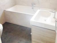 A stunning bathroom with a walk in shower, bath and wash hand basin fitted by our bathroom fitters.