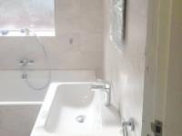 A stunning bathroom with a walk in shower, bath and wash hand basin fitted by our bathroom fitters.